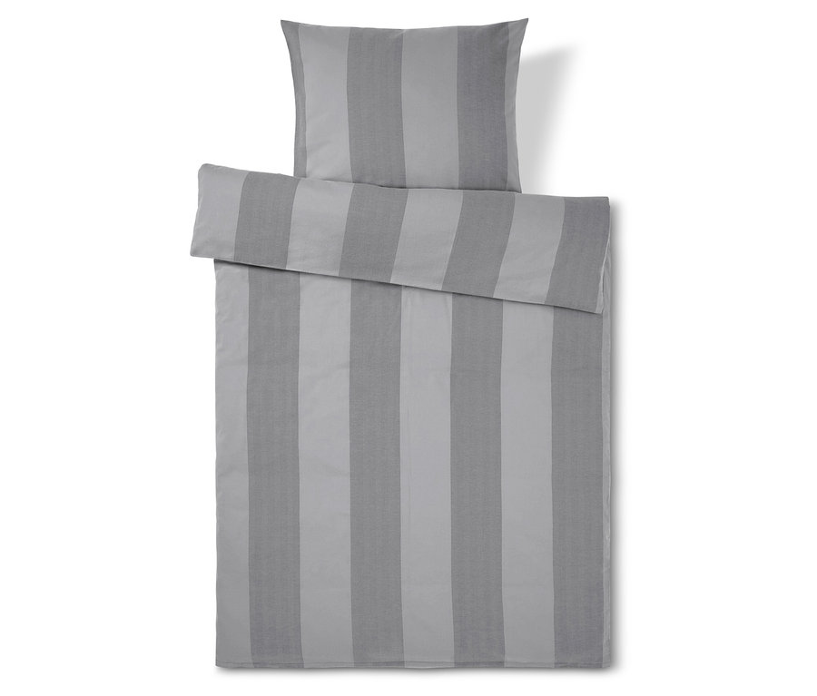 Linge de lit rayé gris avec oreiller sur le dessus.