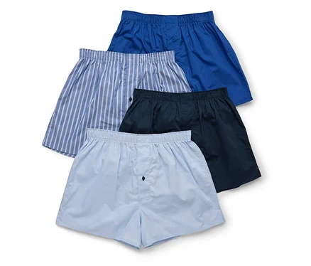 Quatre boxers pour hommes de couleur bleue, rayée, bleu marine et bleu clair sont superposés.