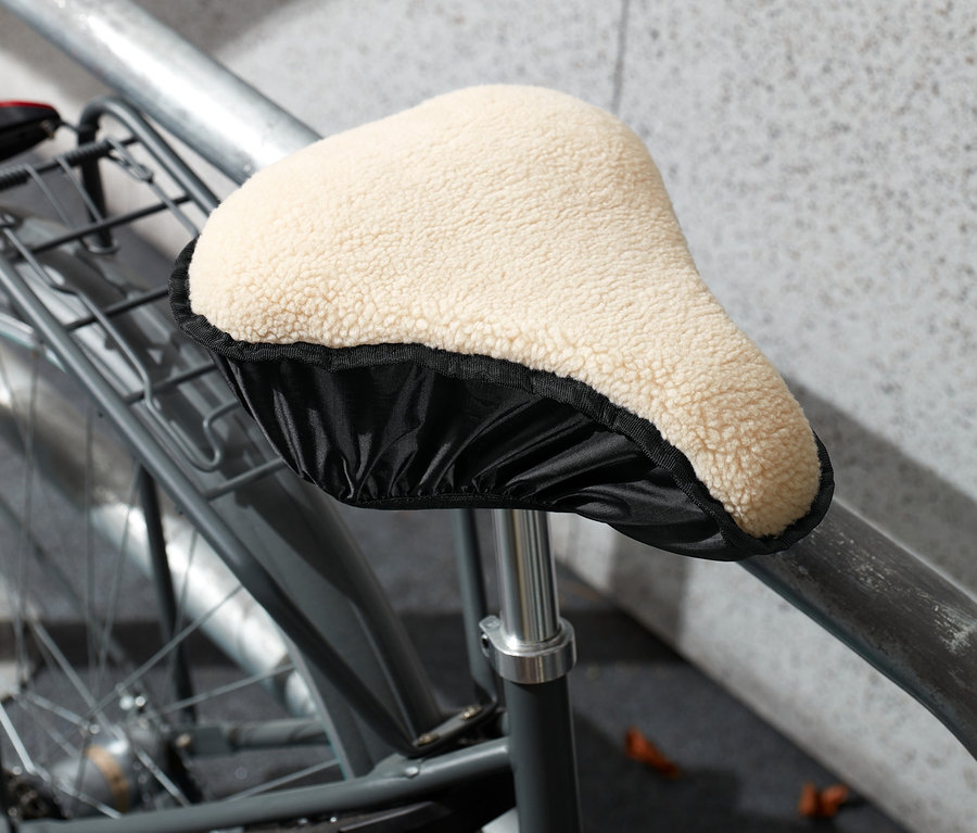 Gros plan d'un vélo avec une housse de selle 2 en 1 beige.