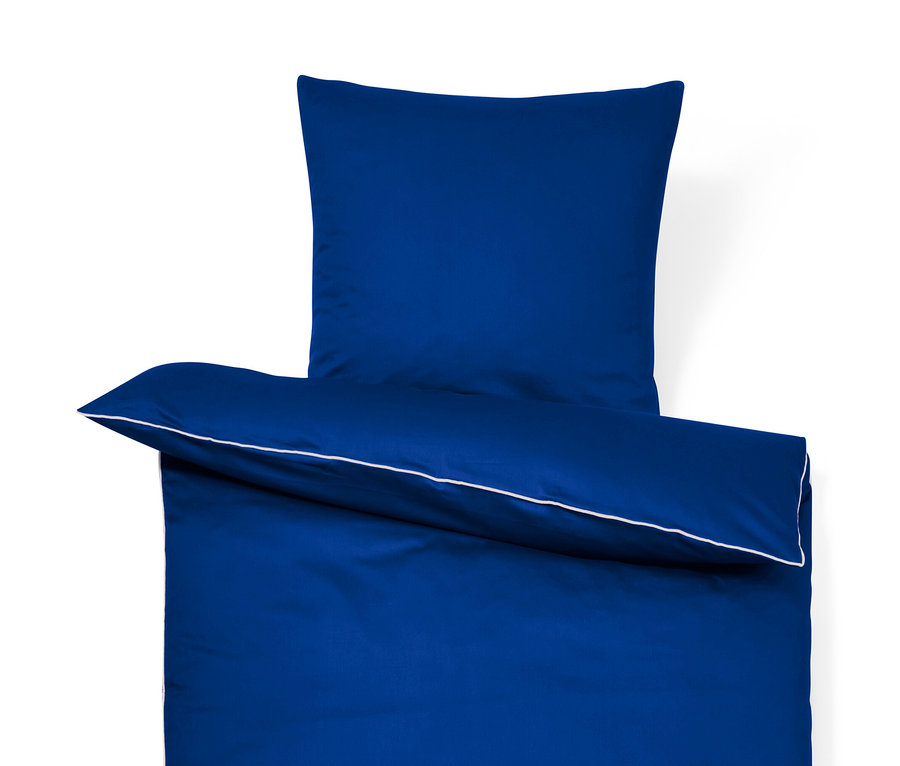 Ensemble de literie en satin bleu : taie d'oreiller et housse de couette avec passepoil blanc.