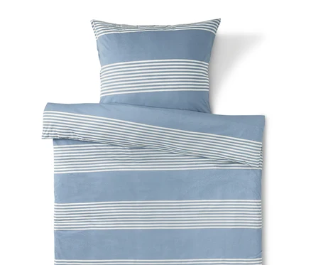Linge de lit bleu rayé blanc avec taie d'oreiller sur le dessus.