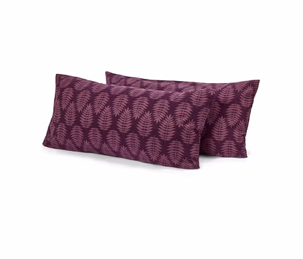 Deux oreillers rectangulaires violets avec un motif de feuilles violet clair, l'un légèrement derrière l'autre, sur fond blanc.