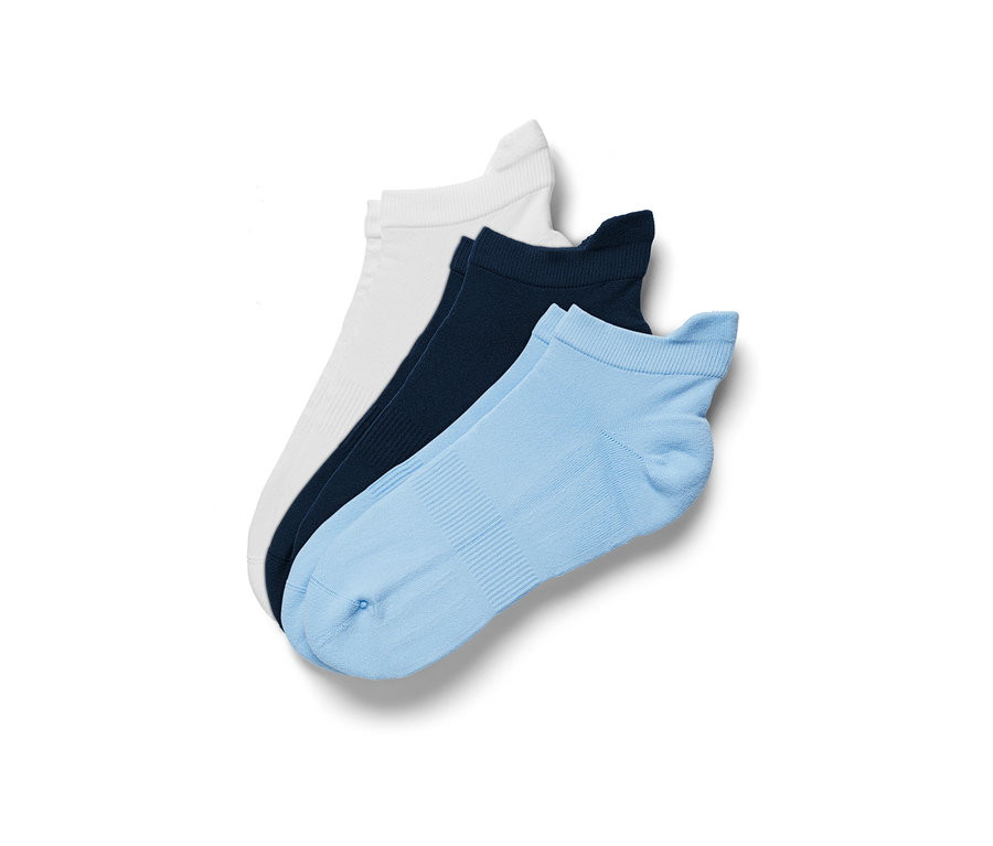 Trois paires de chaussettes de sport fonctionnelles sont posées sur un fond blanc : blanc, bleu foncé et bleu clair.