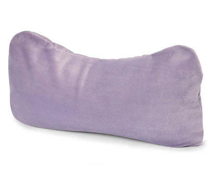 Un coussin violet en forme d'os repose sur une surface blanche.