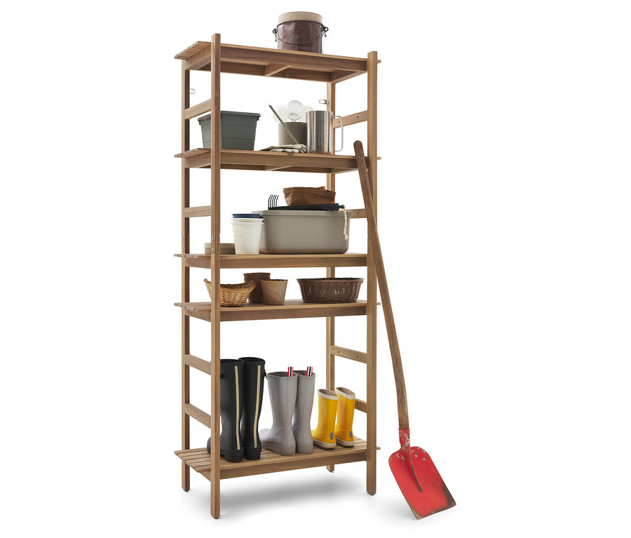 Une étagère en bois avec des outils de jardinage et des bottes. Une pelle rouge est appuyée sur le côté.