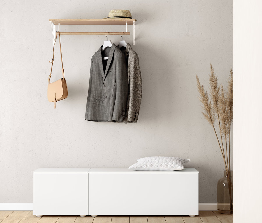 Un banc d'environ 50 cm et un banc d'environ 100 cm sont placés sous une étagère murale. Une veste et un sac à main sont suspendus à l'étagère. Un coussin repose sur le banc.