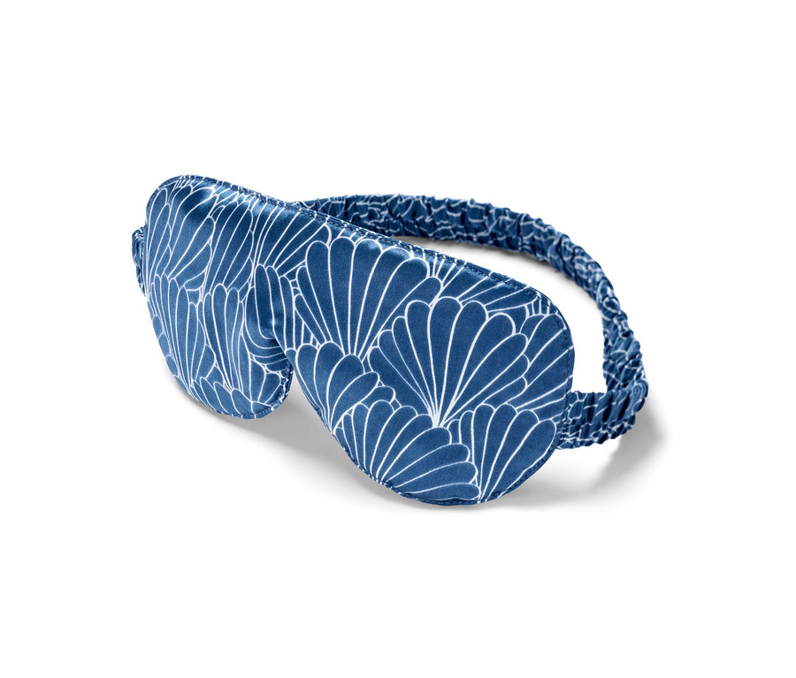 Masque de nuit en soie bleu avec motif blanc.