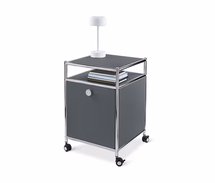 Caisson en métal à roulettes « CN3 » gris avec abattant, lampe et livres.