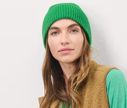 Femme portant un bonnet en maille vert.