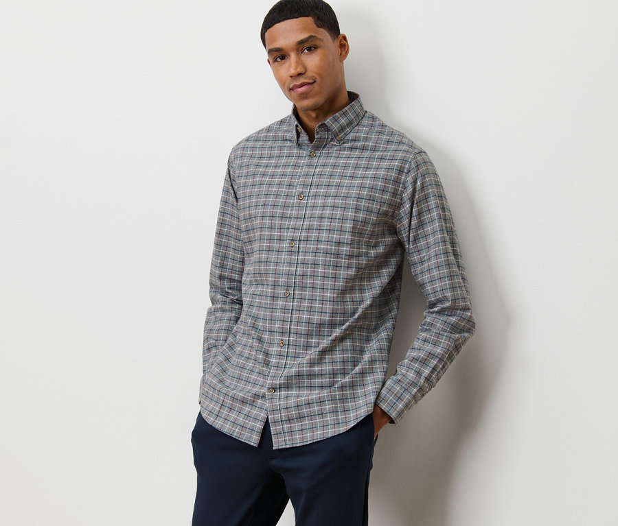 Homme posant en chemise de flanelle grise.