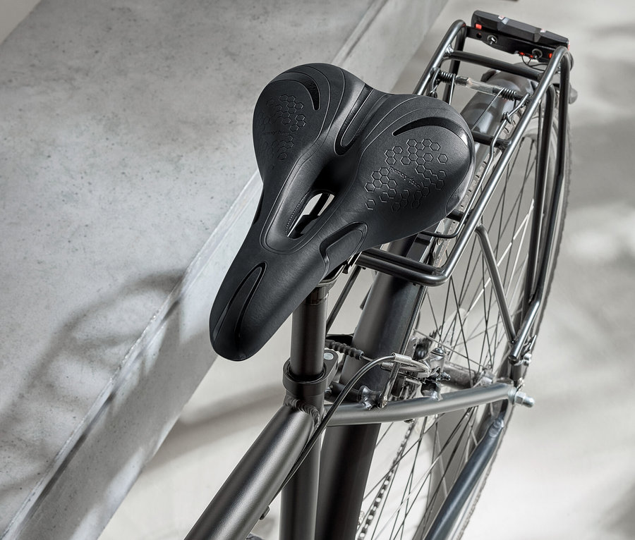 Vélo noir avec selle noire et casque noir sur une surface en béton.