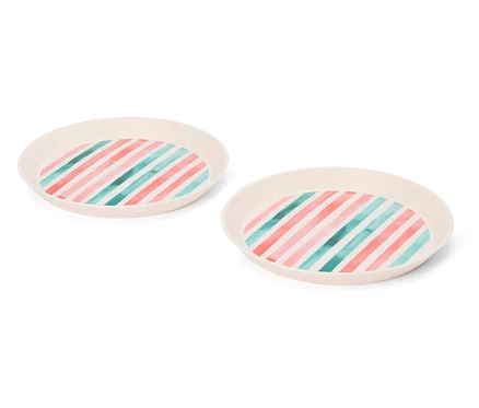 Deux assiettes rondes beiges à rayures roses et turquoise sur fond blanc.