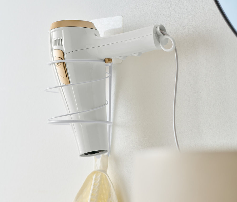 Un sèche-cheveux blanc est placé dans un support à sèche-cheveux.