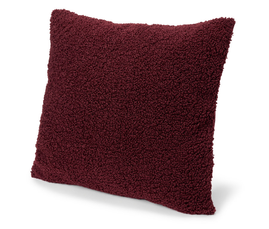 Coussin décoratif bordeaux en fausse fourrure.