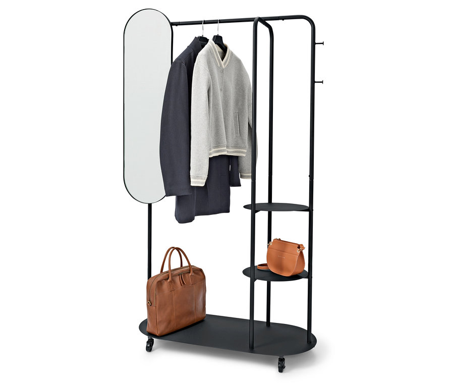 Porte-vêtements noir avec miroir ovale, manteau, pull, pantalon et deux sacs marron.