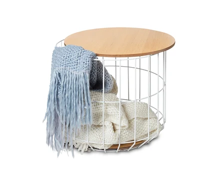 Une table de salon avec plateau amovible contenant une couverture et un châle posé sur le dessus.
