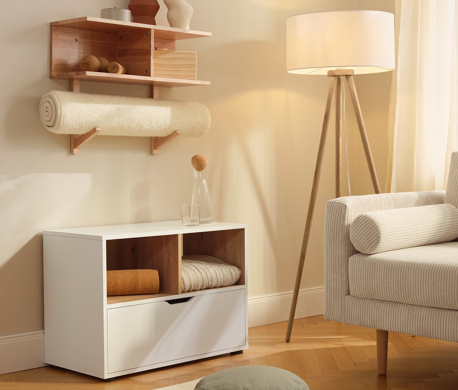 Un buffet avec tiroir est à côté d'un tapis de yoga en laine vierge. Une étagère murale est accrochée au mur.