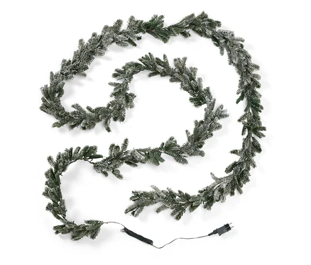 Guirlande décorative en sapin avec effet enneigé et câble d'alimentation sur fond blanc.