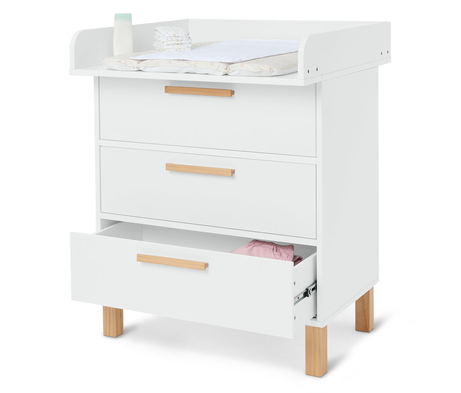Table à langer blanche avec trois tiroirs, couches, crème et matelas à langer.