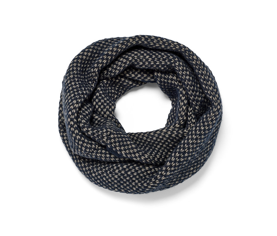 Gros plan d'une écharpe tube tricotée bleu marine et beige.