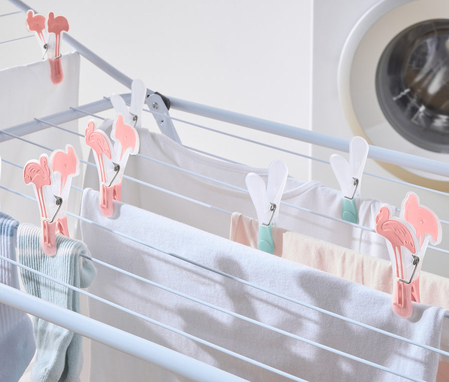 Le linge est suspendu à un séchoir et fixé par 20 pinces à linge.