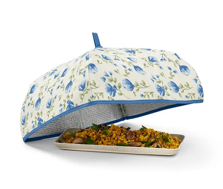 Nourriture sur une assiette recouverte d'une couverture isotherme à fleurs bleues.