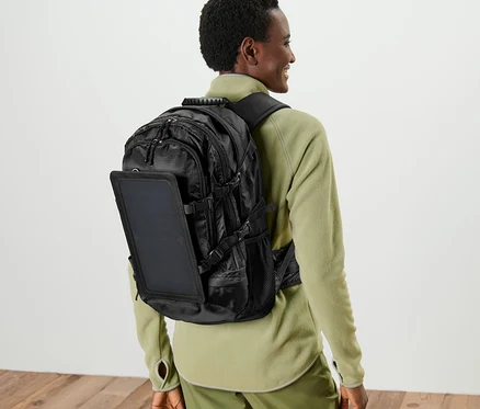 Femme portant un sac à dos solaire noir.
