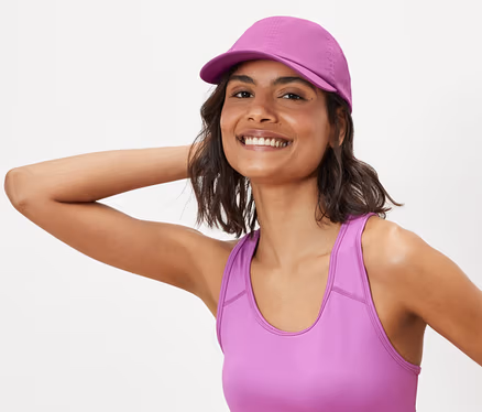Femme posant en soutien-gorge de sport et casquette de sport.