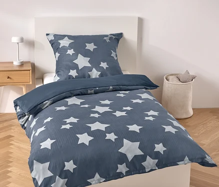Literie bleue avec des étoiles sur un lit.