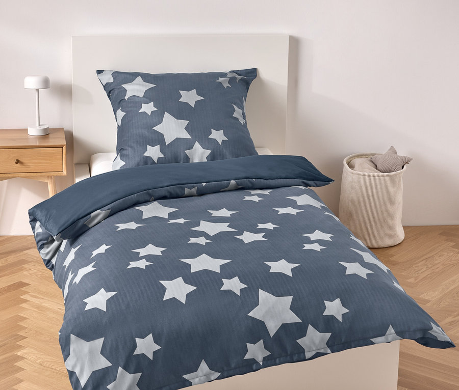 Literie bleue avec des étoiles sur un lit.