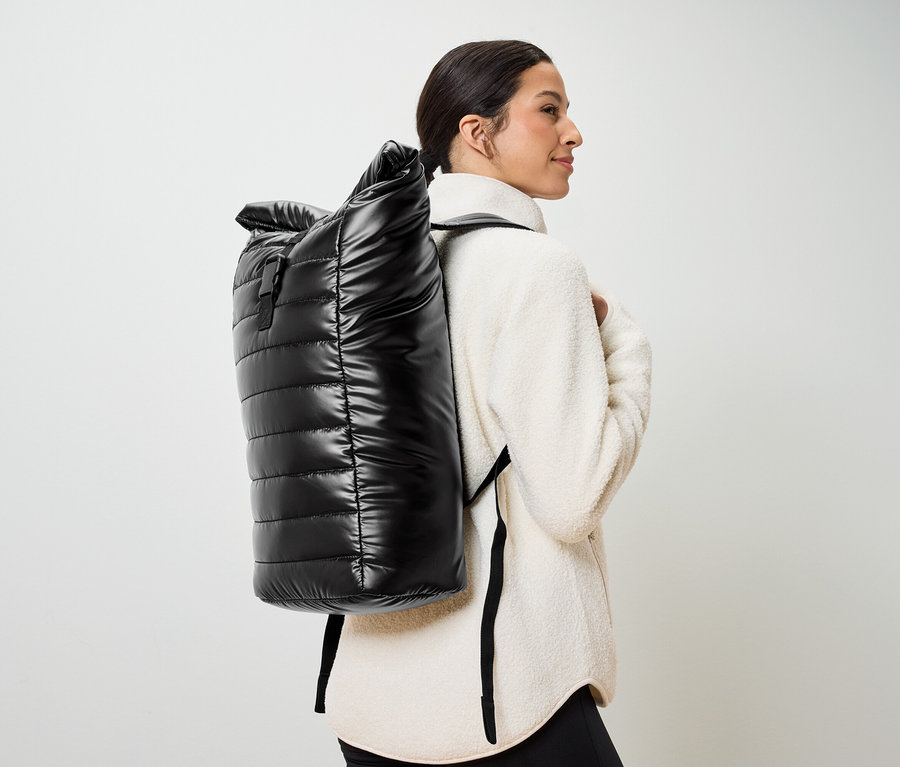 Femme portant un sac à dos matelassé noir.