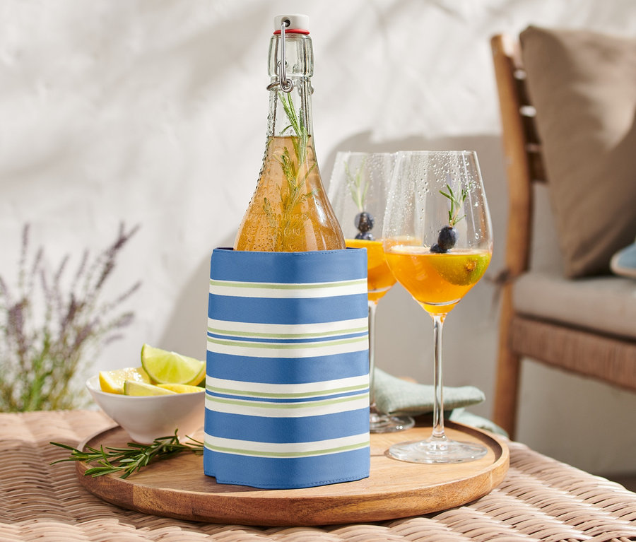 Bouteille dans une manchette de refroidissement sur une table à côté de deux verres de boisson.