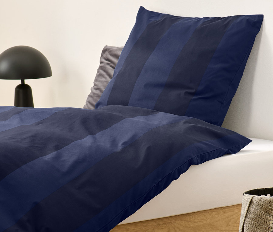 Parure de lit en flanelle bleu rayé de taille standard sur un lit.