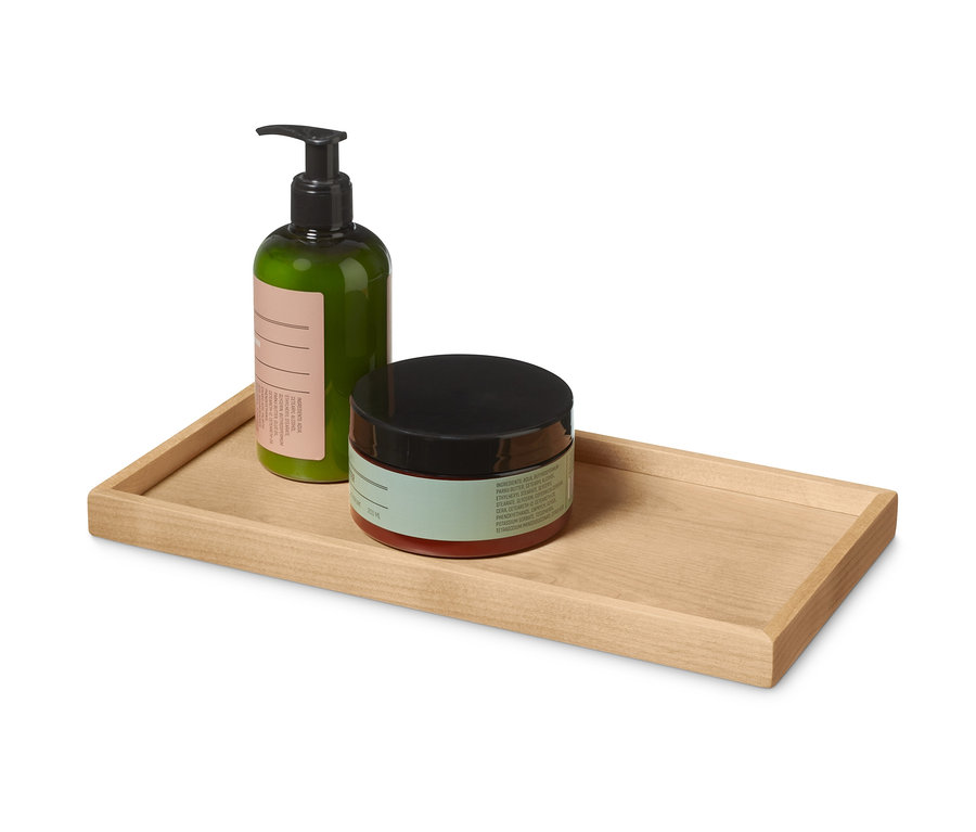 Bouteille verte et pot avec couvercle noir sur un plateau en bois.