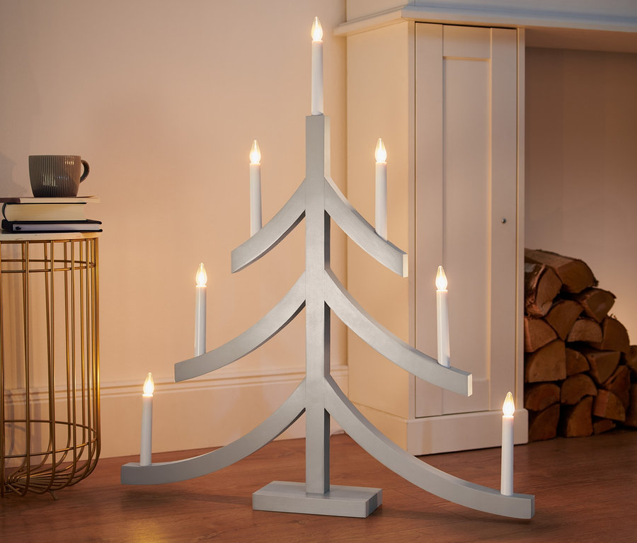 Un chandelier LED XL gris en forme de sapin de Noël est posé sur le sol.