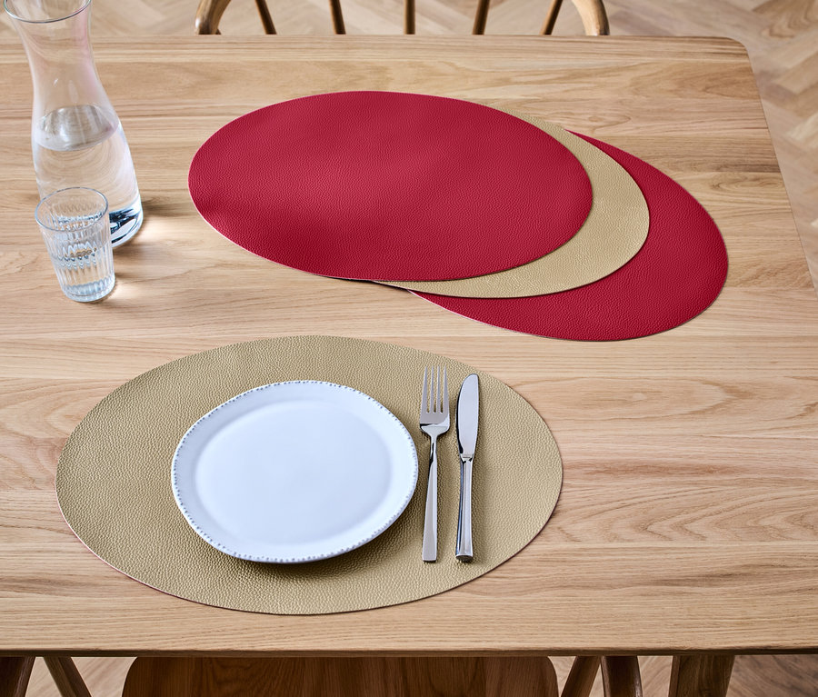 Sur une table en bois sont posés 4 sets de table réversibles.