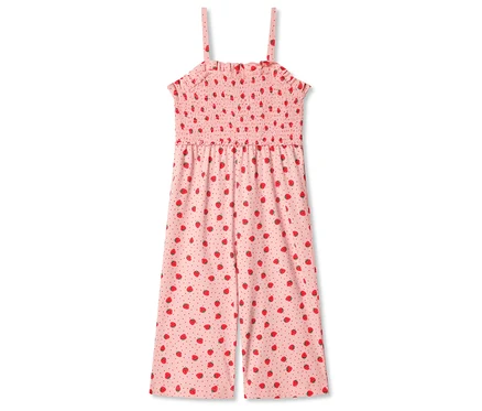 Une combinaison rose à motifs de fraises et à bretelles spaghetti est posée sur un fond blanc.