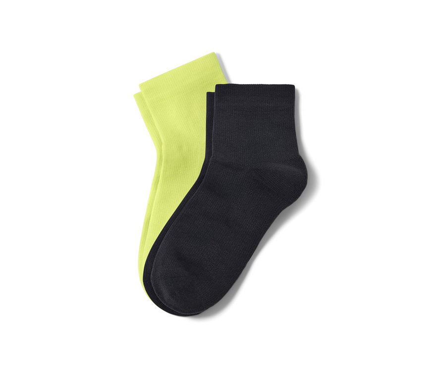 Deux paires de chaussettes de sport courtes : une paire vert néon, une paire noire.