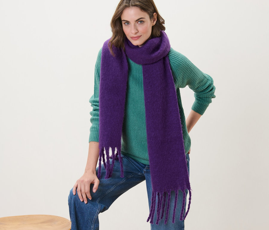 Femme posant avec une écharpe tissée violette.