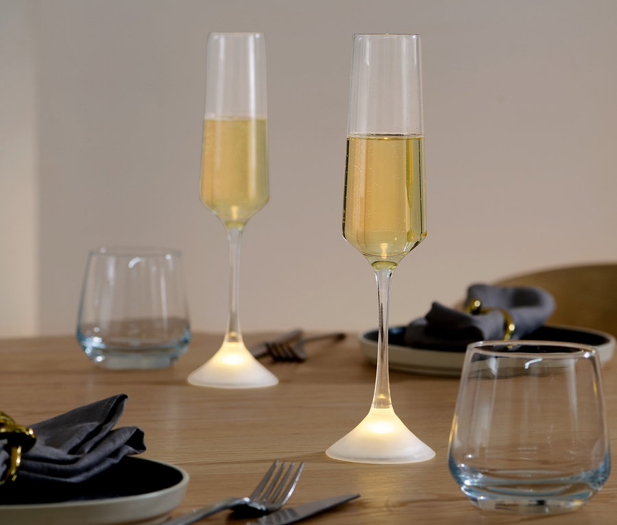 Deux verres de champagne à LED sur une table.