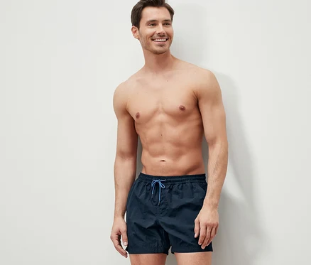 Homme souriant portant un short de bain.