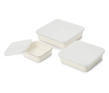 Trois boîtes de conservation carrées crème avec couvercles blancs, dont une sans couvercle.