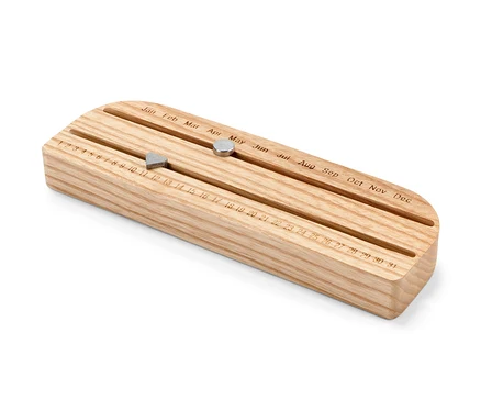 Calendrier éternel en bois avec aimants coulissants indiquant le jour et le mois.