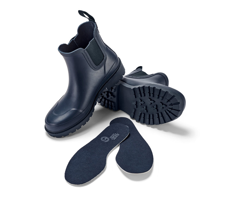 Bottines de pluie bleu marine et semelles intérieures sur fond blanc.