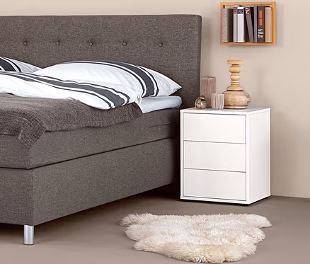 Lit boxspring avec table de chevet boxspring et décorations.
