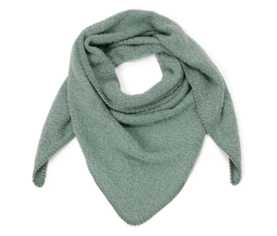 Un châle triangulaire vert clair en bouclette est posé sur un fond blanc.