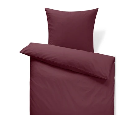 Linge de lit bordeaux avec oreiller et couette.
