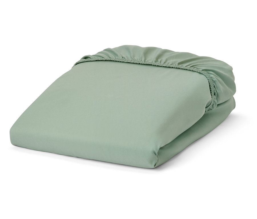 Un drap-housse vert en microfibre est plié.