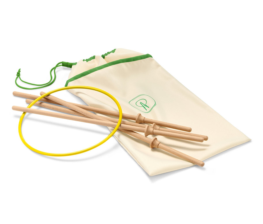 Un anneau volant jaune, des bâtons en bois et un sac en tissu crème avec une bordure verte.