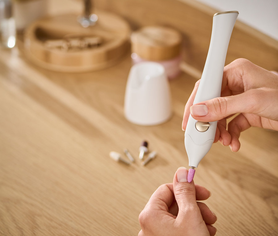 Une femme utilise un kit manucure-pédicure 5 en 1 sur ses ongles.